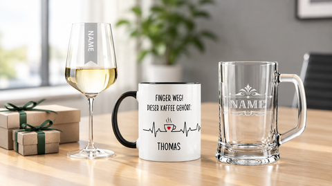 Personalisierte Mitarbeitergeschenke: Weinglas und Bierkrug mit Namensgravur sowie Tasse mit dem Aufdruck Finger weg, dieser Kaffee gehört Thomas