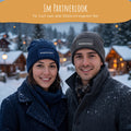 Paar im Schnee mit personalisierten Mützen in Navy und Graphit im Partnerlook