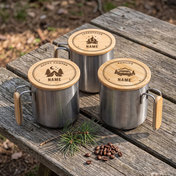 Drei Edelstahlbecher mit gelasertem Bambusdeckel und Namen auf einem Holztisch