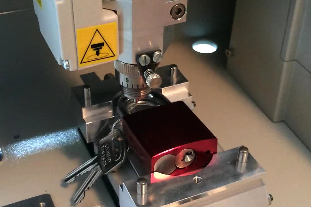 Archivbild vom Juni 2014: ein rotes Liebesschloss in der Graviermaschine Gravograph M20 (Standbild aus einem Video)