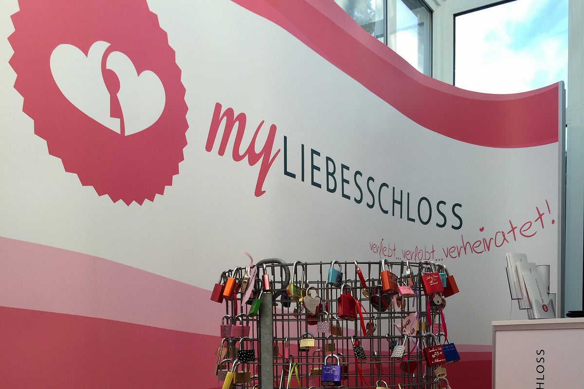 Archivbild vom April 2015: Wand mit dem Logo von myLiebesschloss und ein Gitterkorb mit Liebesschlössern an der Drüenstraße