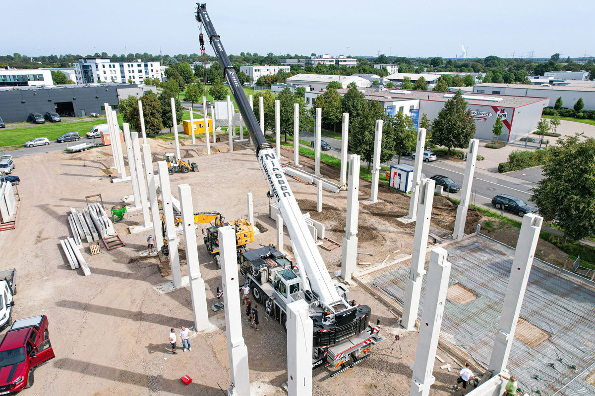 Baustelle Alexander-Bell-Straße 9 im August 2023: Ein Kran setzt die Betonstützen der neuen Halle