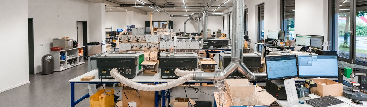 Arbeitsplätze mit Lasern und Bildschirmen in der Produktion von GRAVURZEILE