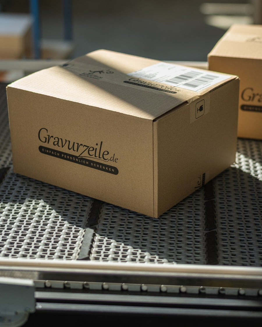Paket mit GRAVURZEILE-Aufdruck auf der Rollenbahn