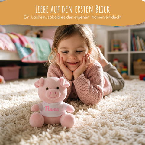 Mädchen lächelt Kuscheltier Schwein mit Namen an